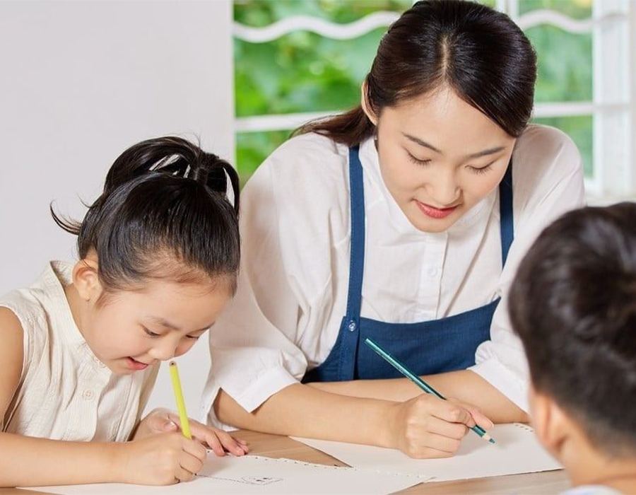 Cô giáo hướng dẫn bé tập viết trong khóa đào tạo giáo viên tiền tiểu học
